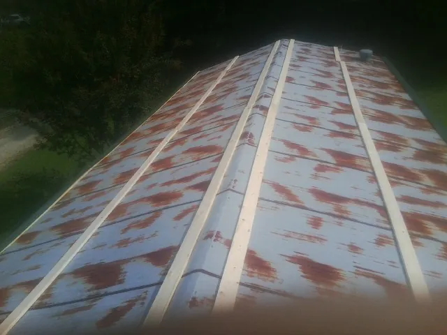 Rusted metal roof panels with new wood purlins before replacement — Storm Damage Roof Repair in Bruceton Mills by Roofing Brothers
