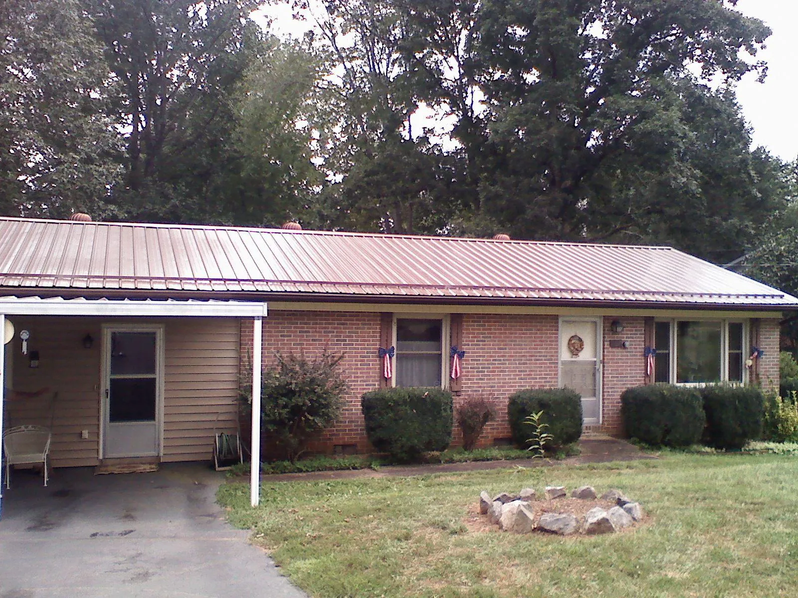 Bronze metal roof and carport on a brick ranch home — Roof Repair work by our crew in Bruceton Mills